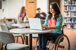 Image of a teacher in wheelchair using a computer.